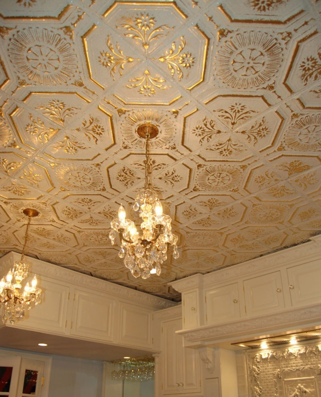 Pale decorative ceiling with gold-highlighted patterns and chandeliers