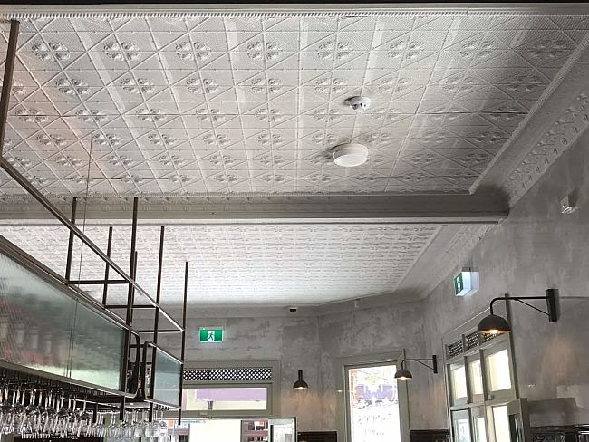 White decorative pressed-metal ceiling inside the Terminus Hotel